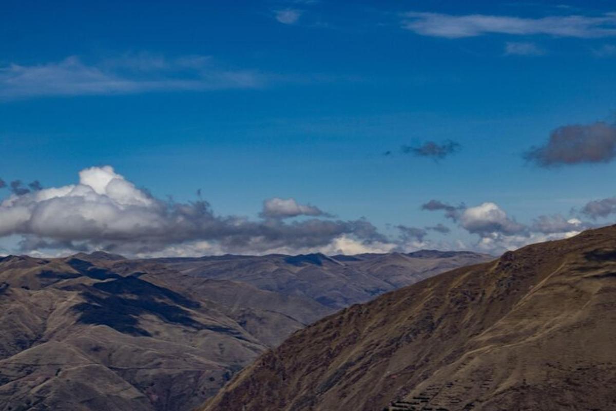 uma vista de uma cadeia de montanhas com nuvens no céu