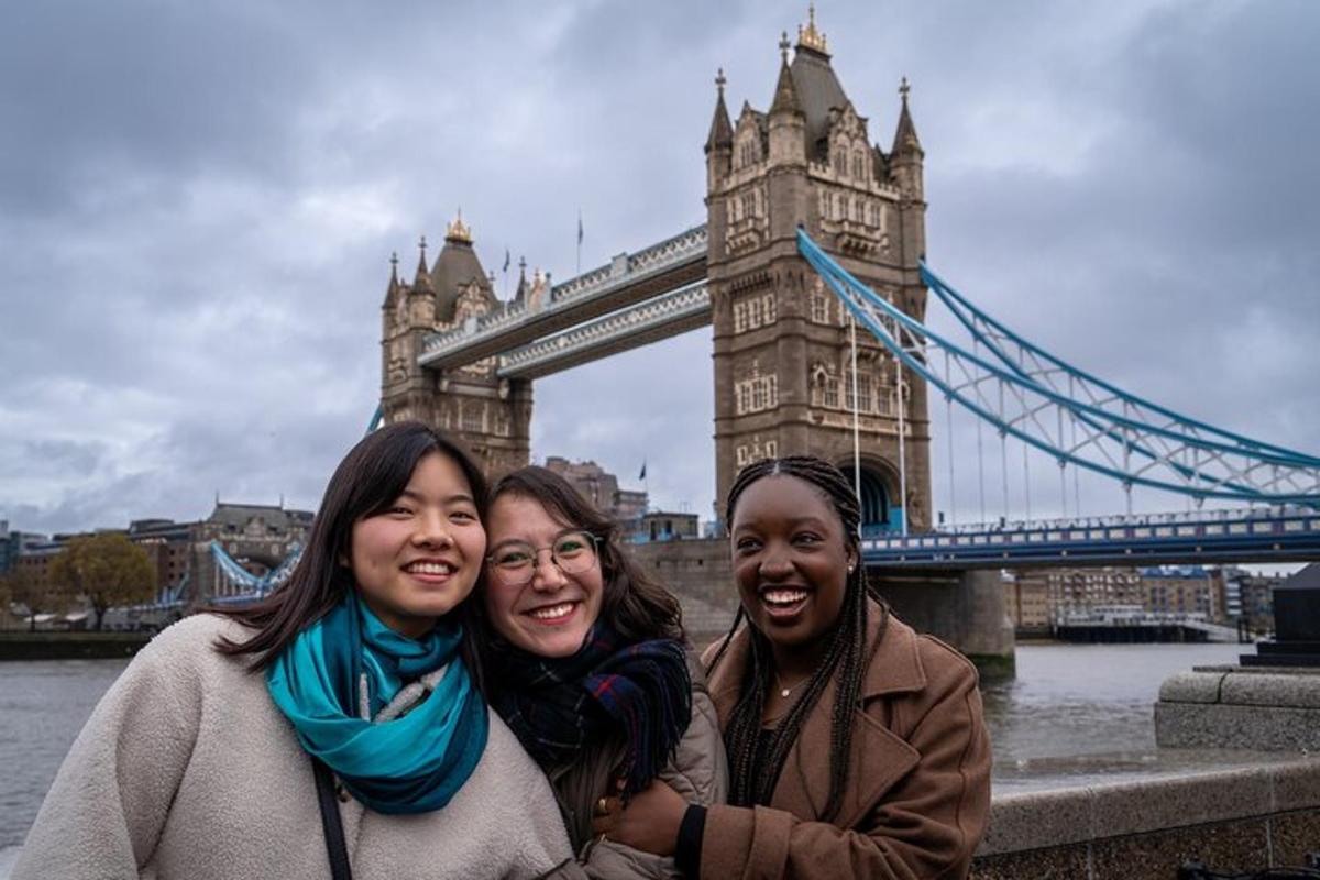 tres dones posant davant del Tower Bridge