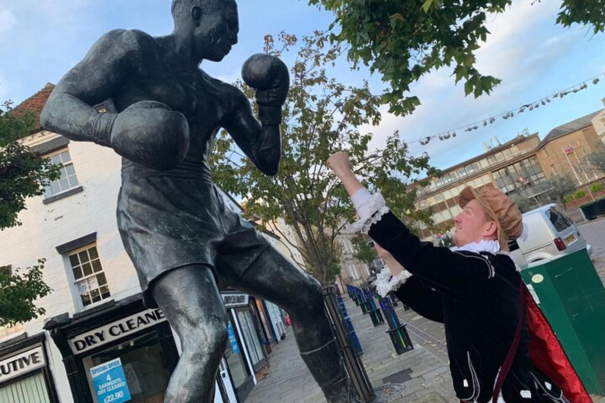 una donna che indica la statua di un giocatore di basket