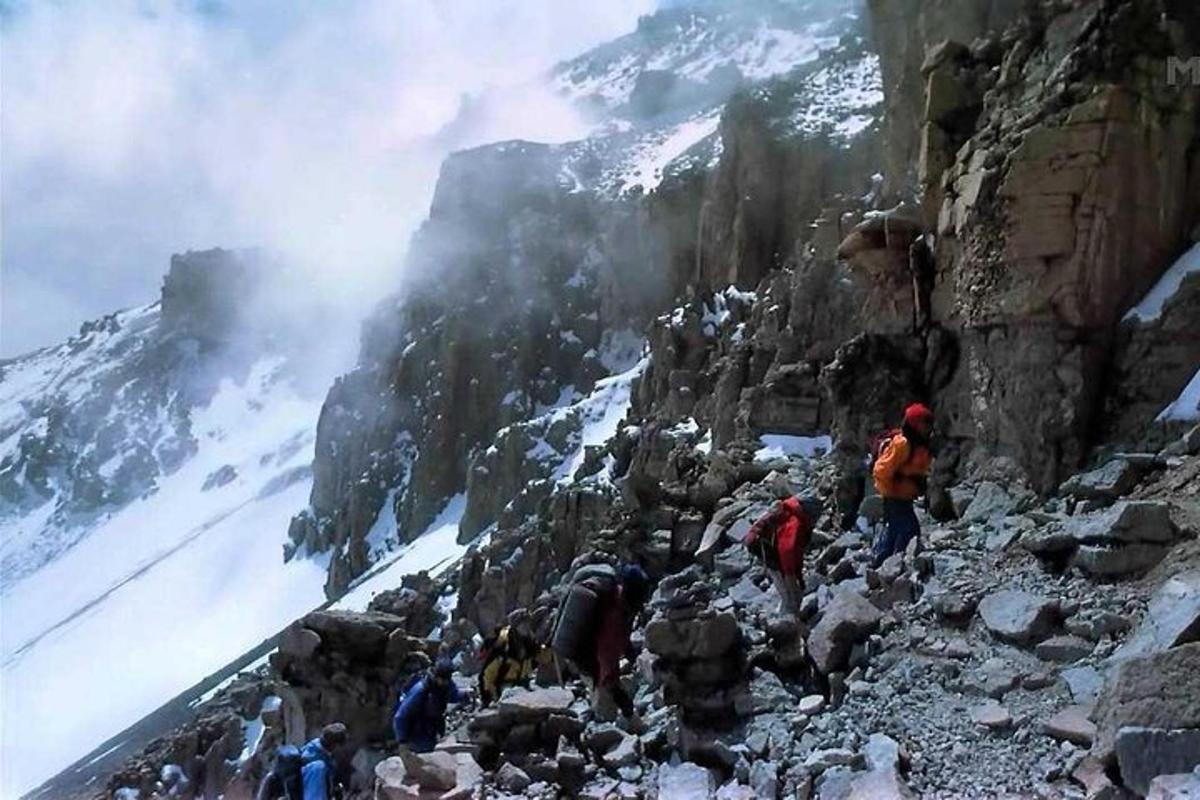 un gruppo di persone che cammina su una montagna rocciosa