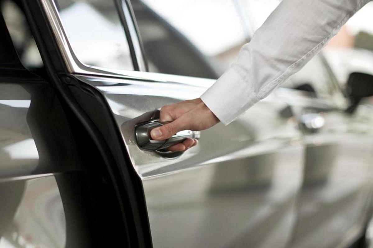 một người đang mở cửa xe ô tô