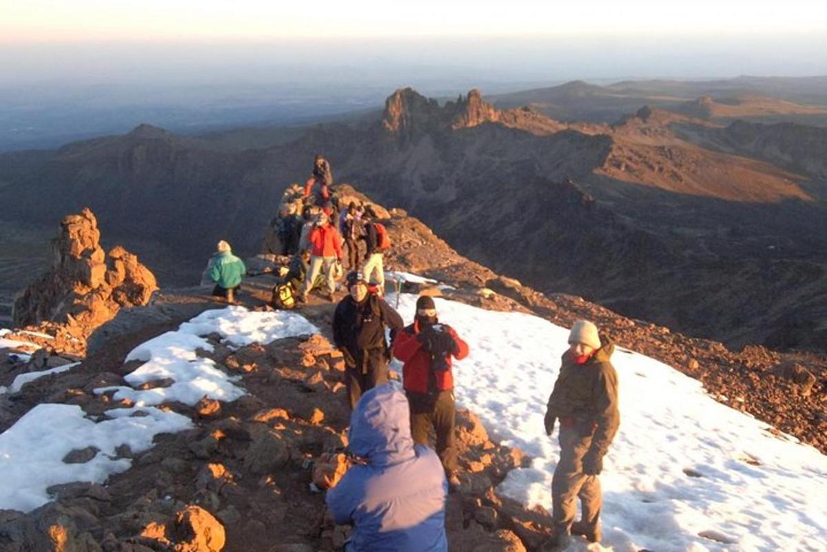 sekumpulan orang berdiri di puncak gunung