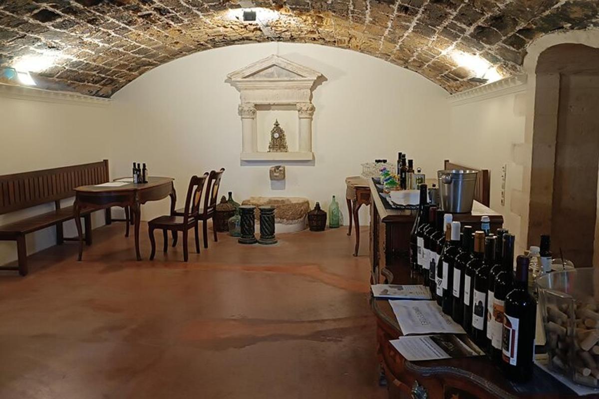 a room with a table and chairs and a room with wine bottles