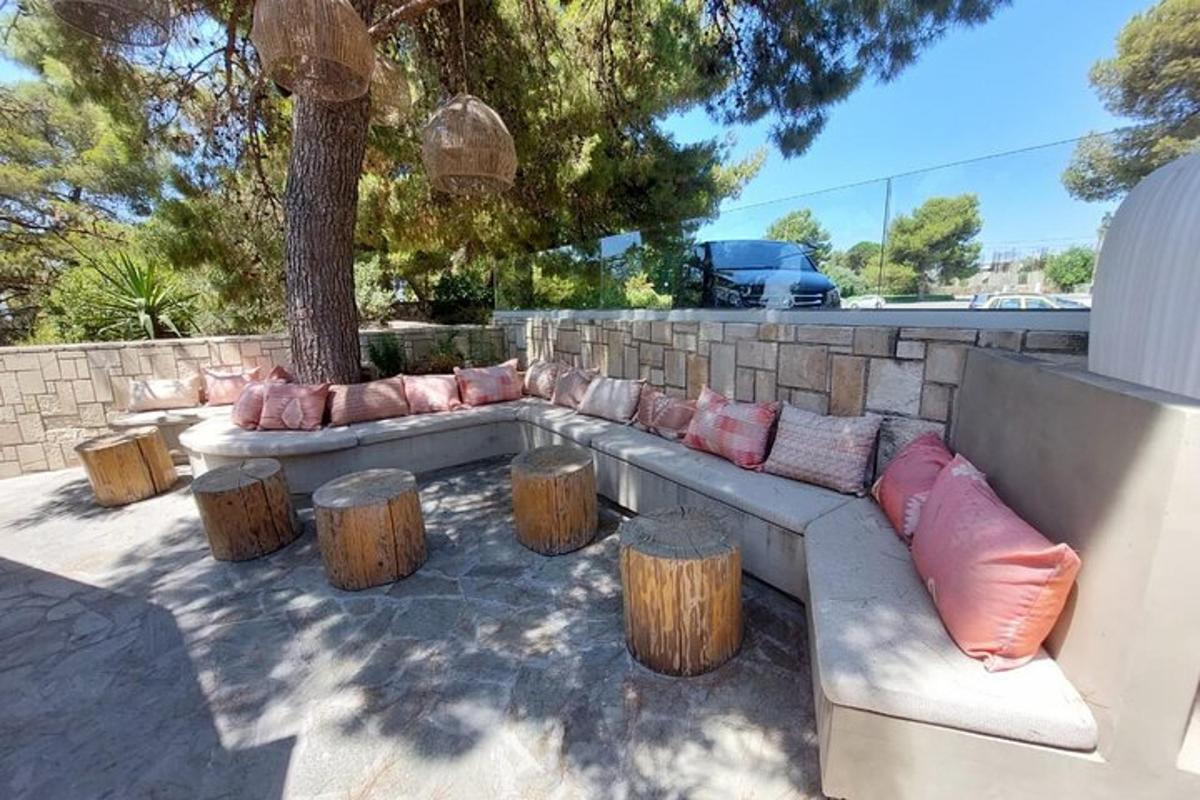 a couch with pillows sitting next to tree stumps