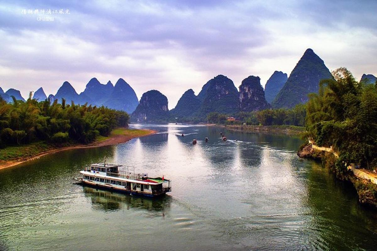 a boat on a river with mountains in the background