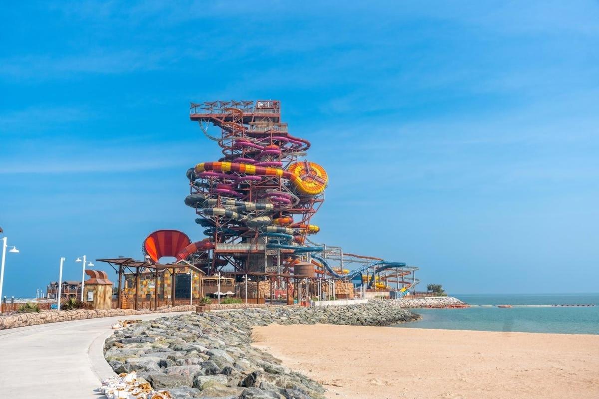 a water park on the beach with a roller coaster