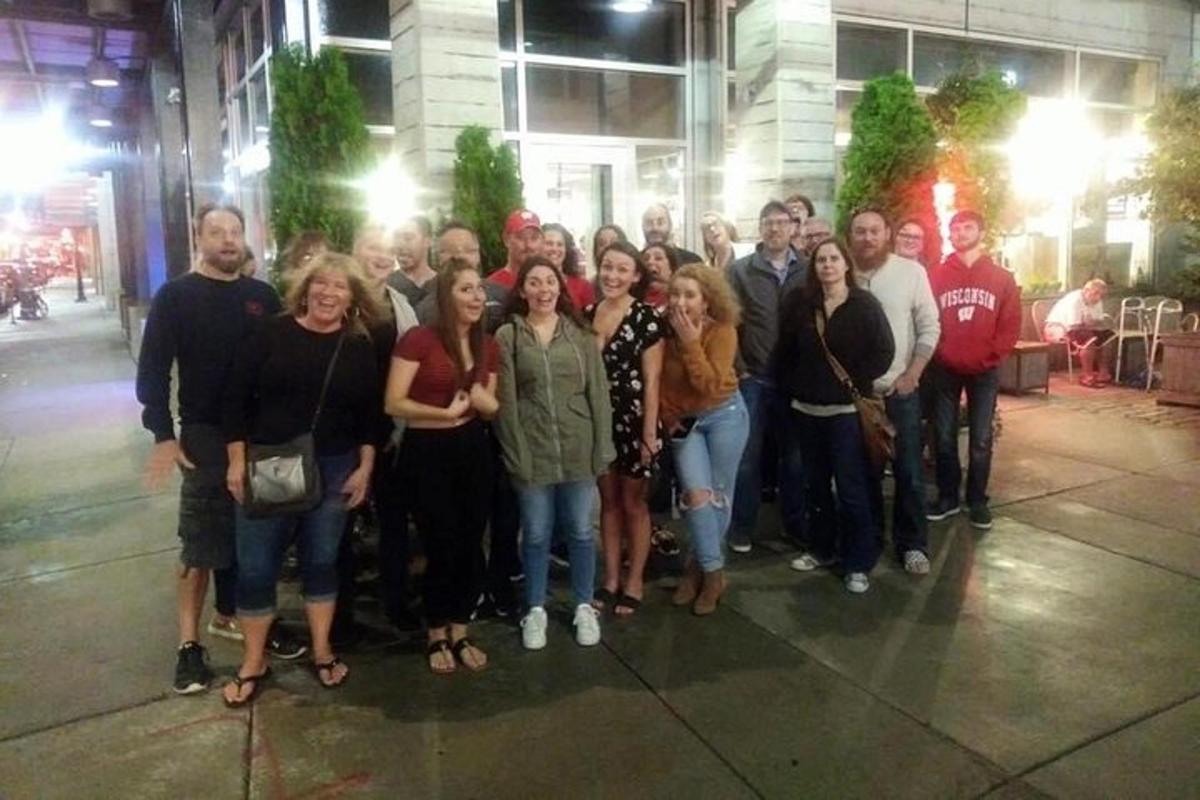 a group of people posing for a picture on the sidewalk