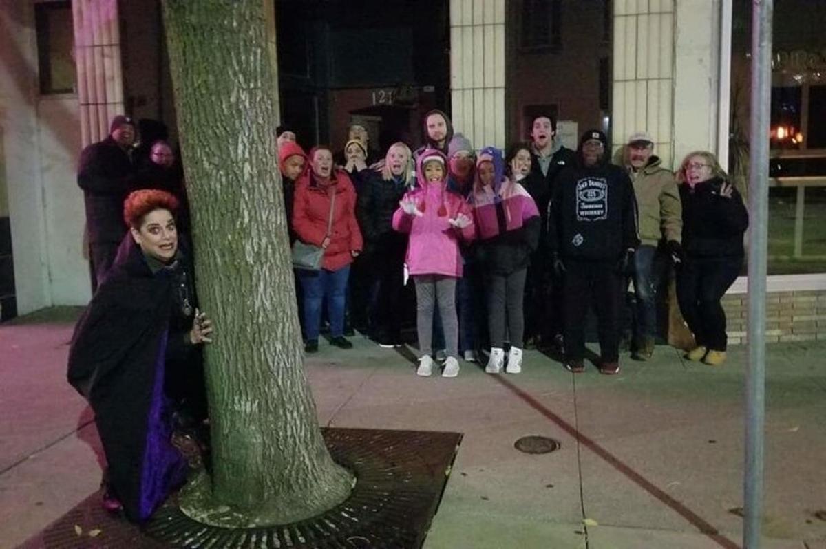 um grupo de pessoas em pé ao redor de uma árvore