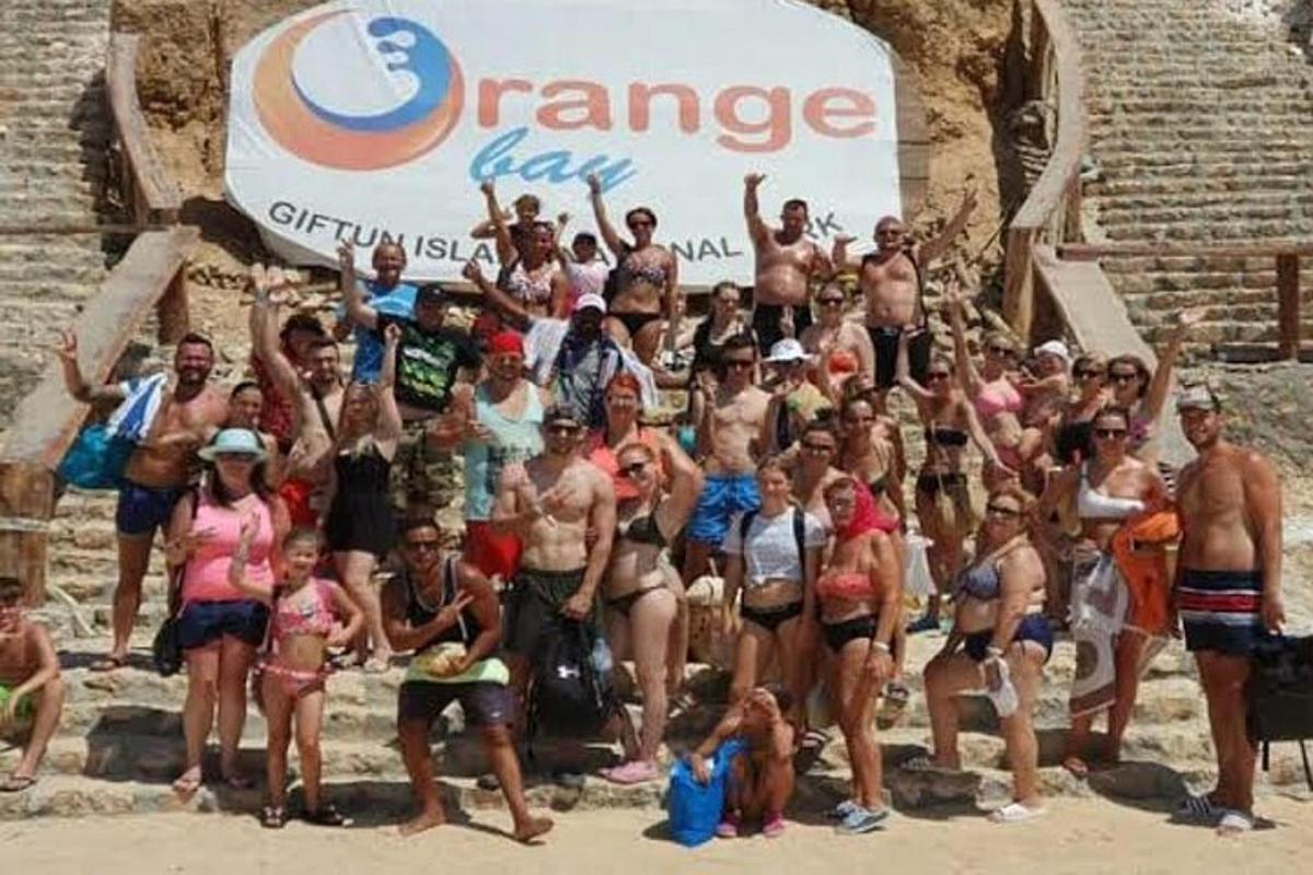 a group of people posing for a picture at the beach