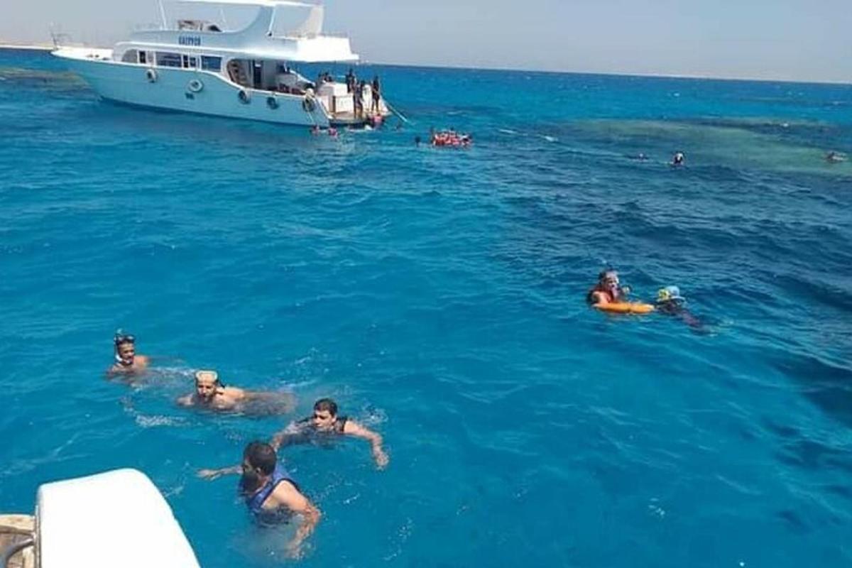 Un grupo de personas nadando en el agua con un bote.