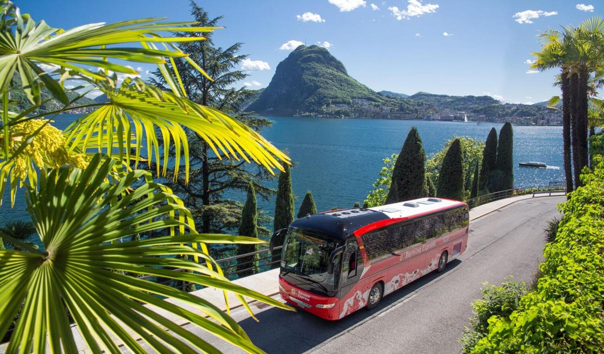 a bus driving down a road next to the water