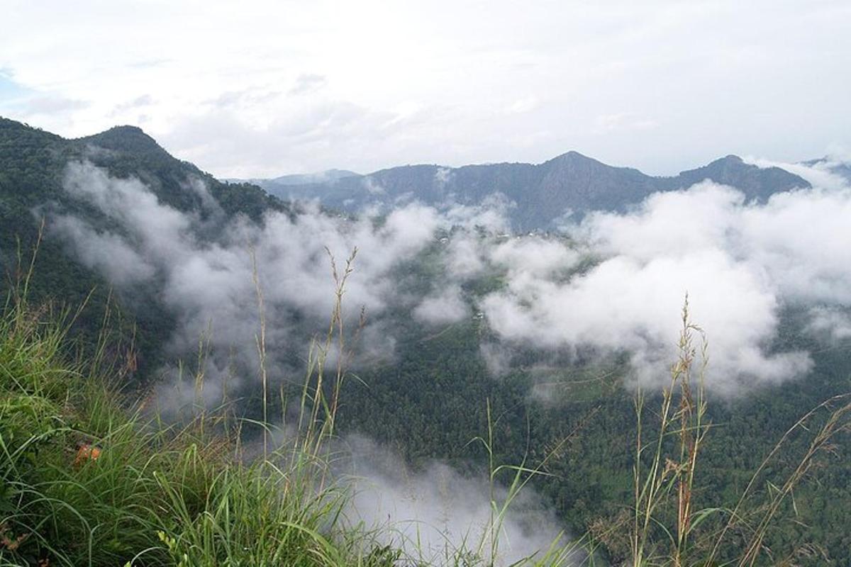 a view of a mountain with clouds in the valley