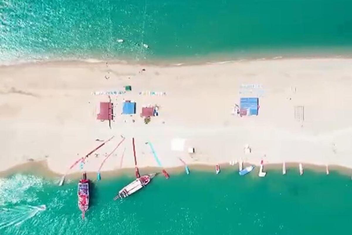 pemandangan udara pantai dengan bot di dalam air