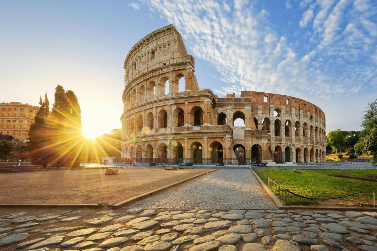 a view of the coliseum with the sun setting