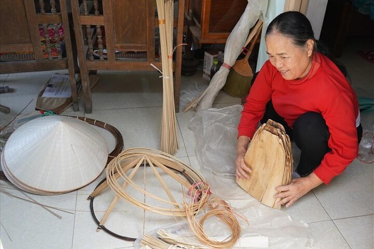 a woman sitting on the floor with a piece of wood