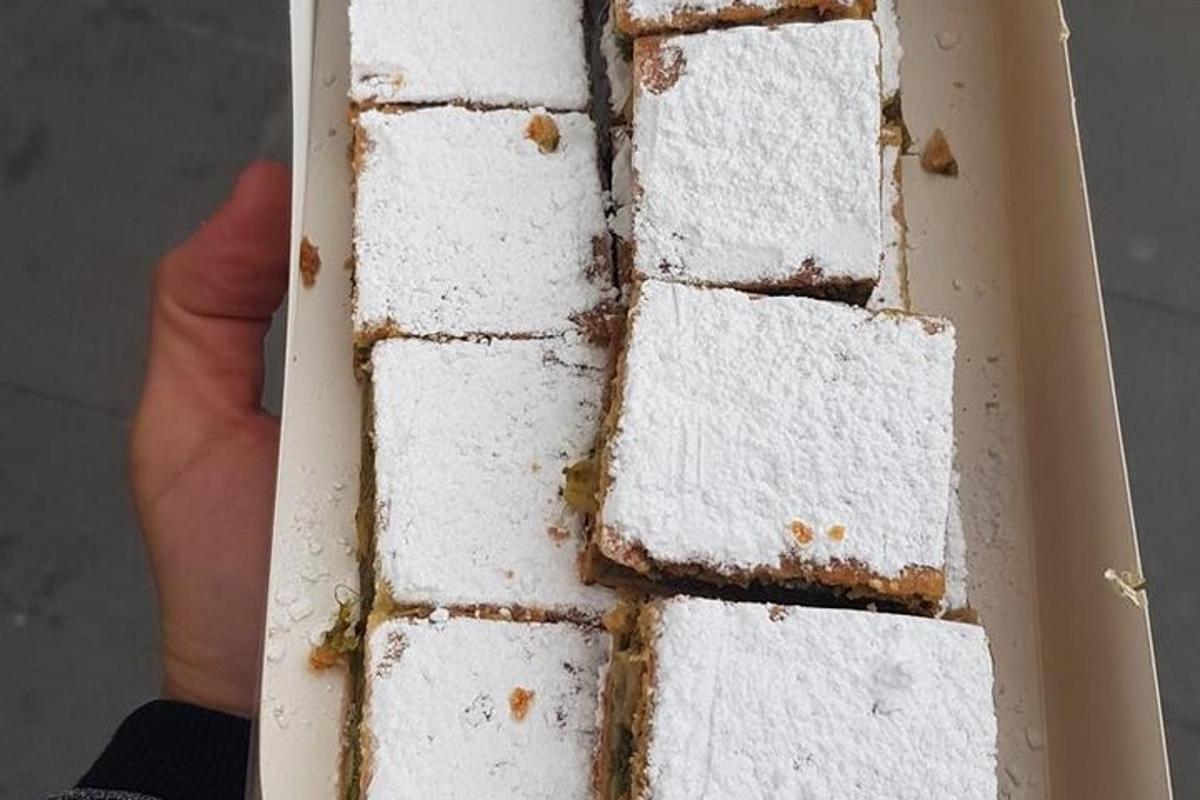 una persona sosteniendo un pastel blanco en una caja