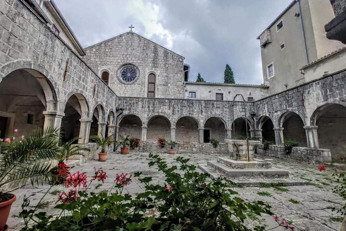 a large stone building with a courtyard with flowers