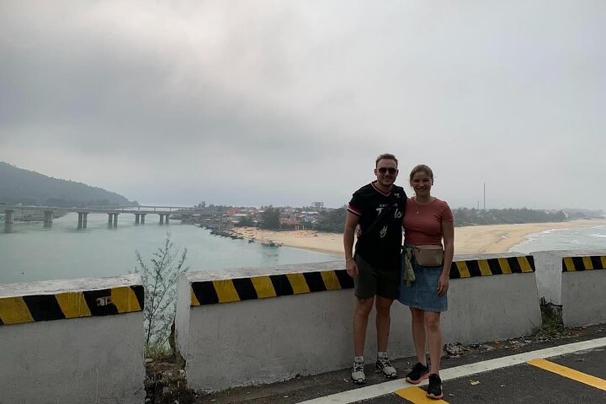 un uomo e una donna in piedi su un muro vicino a una spiaggia