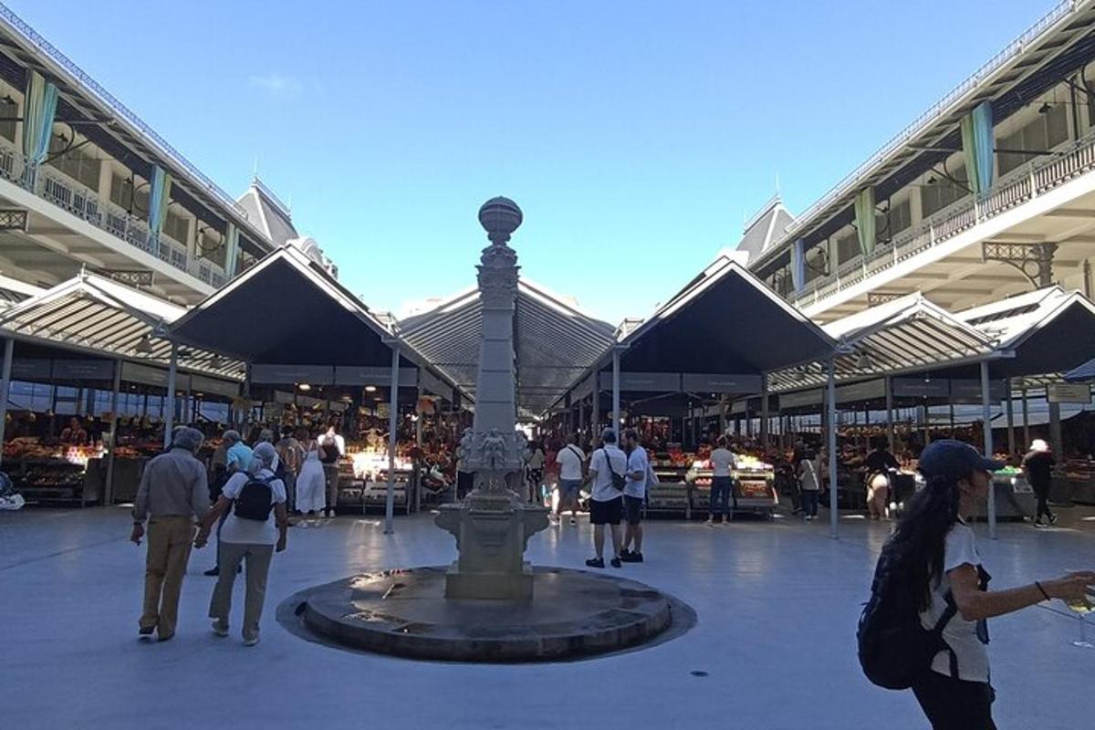 a group of people walking around a fountain in a building