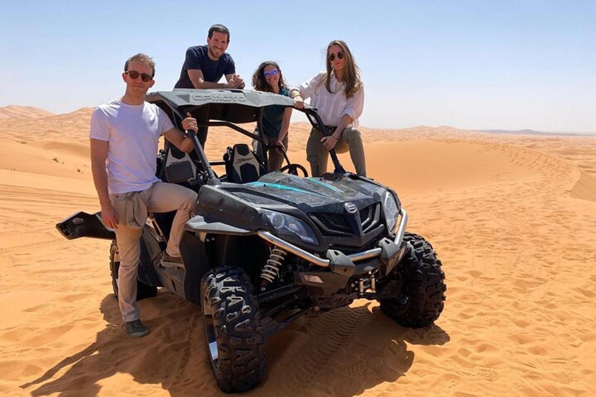 un gruppo di persone sedute su un quad nel deserto