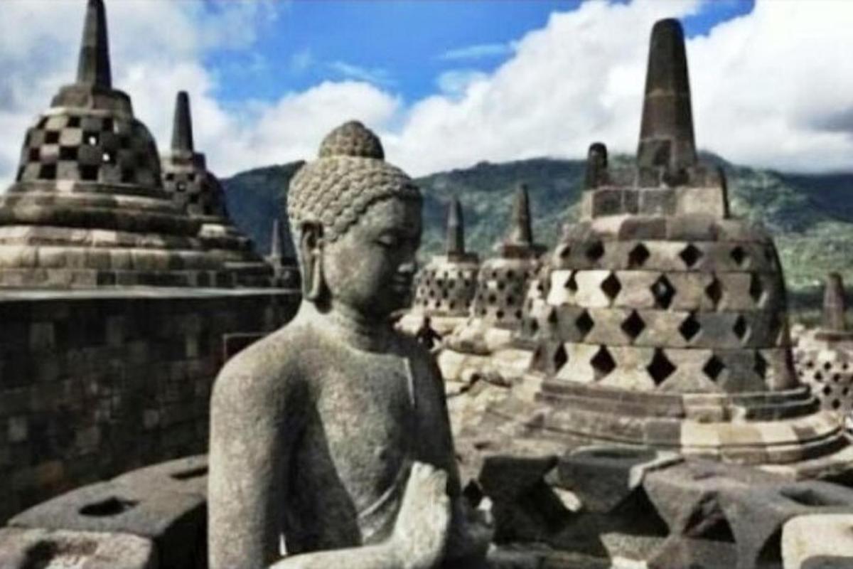 una statua di una donna seduta davanti a un edificio