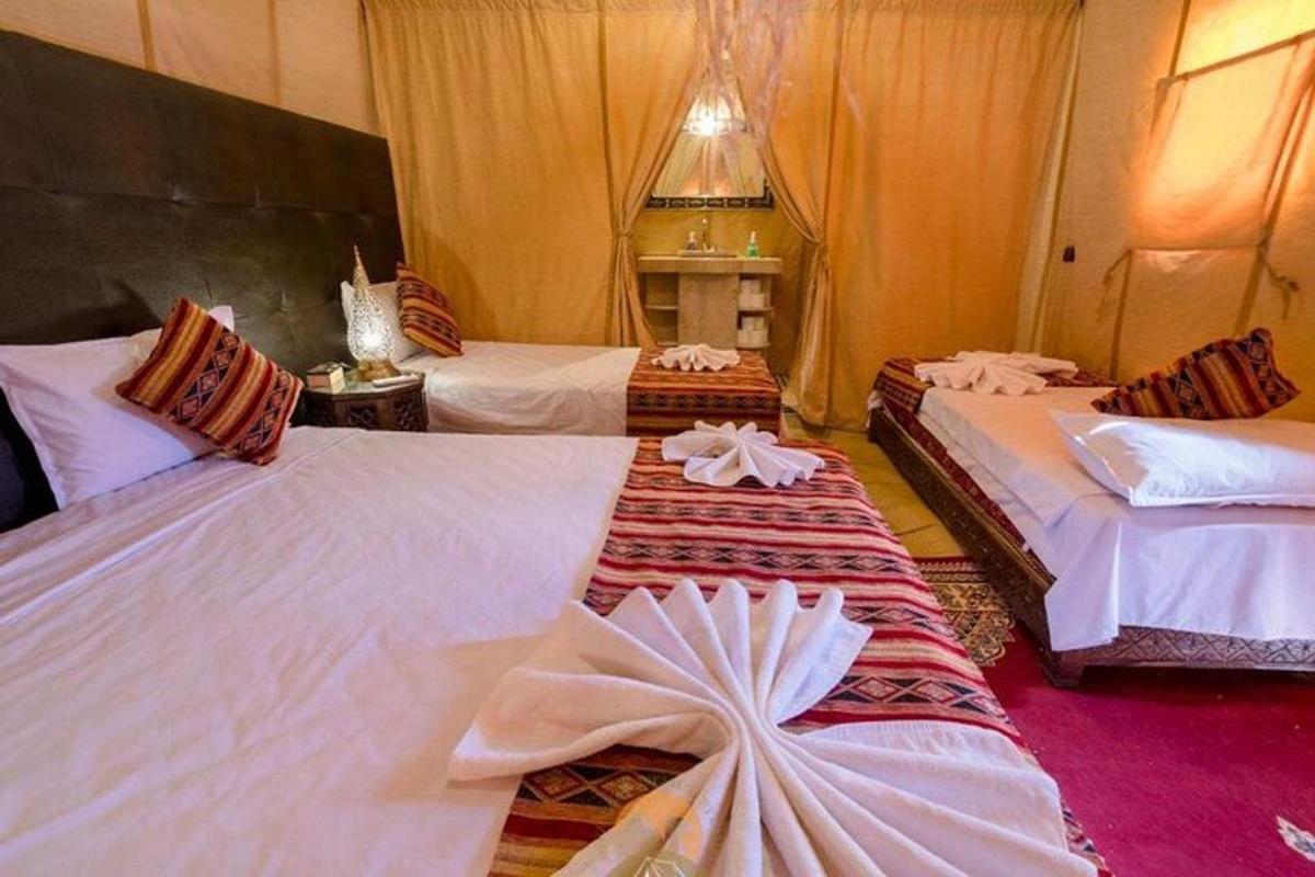 egy hotelszoba két ággyal, fehér lepedővel