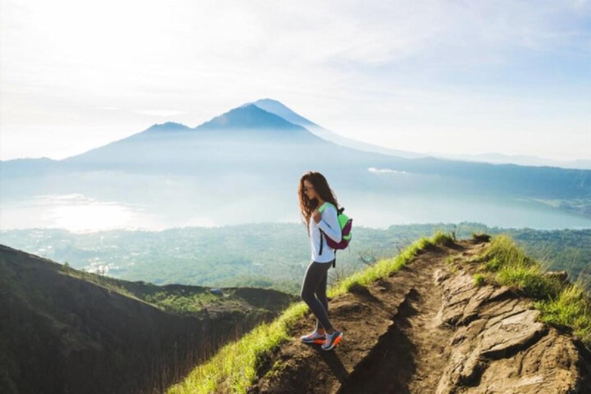 una mujer parada en la cima de una montaña