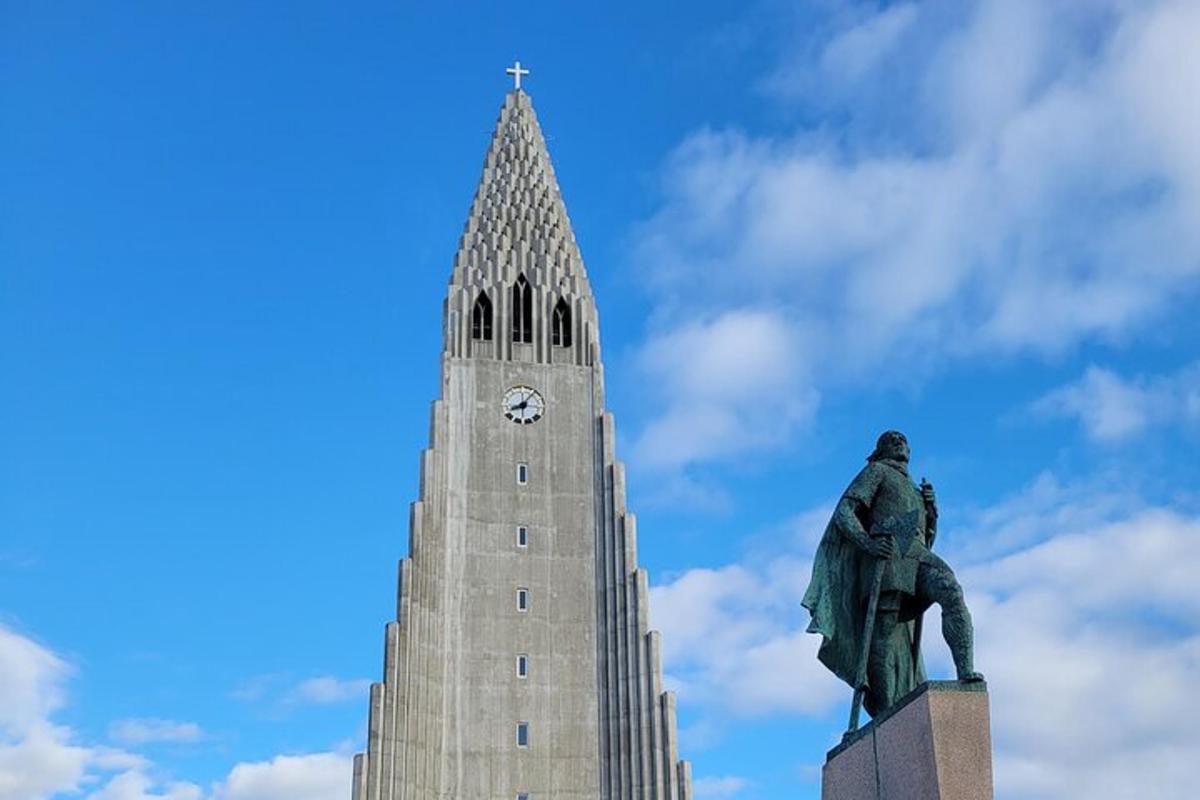 uma estátua em frente a um prédio com uma torre de relógio