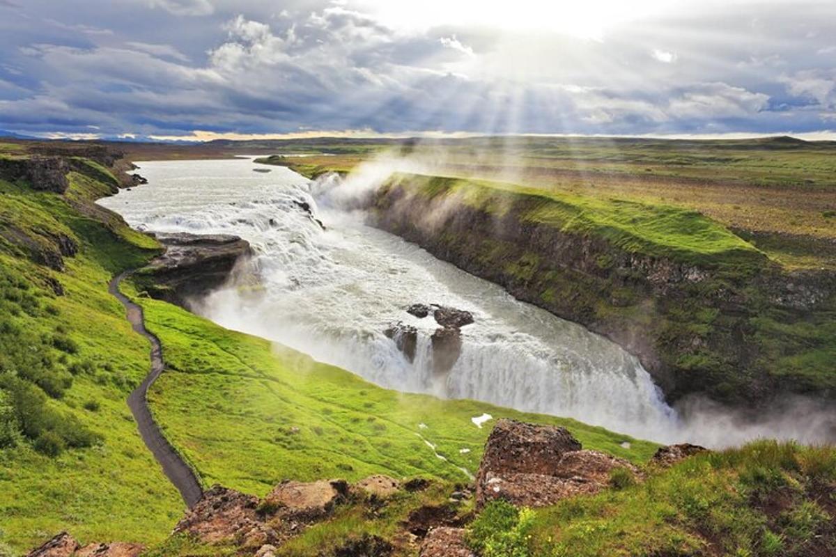 una cascata in mezzo a un campo vicino a un fiume