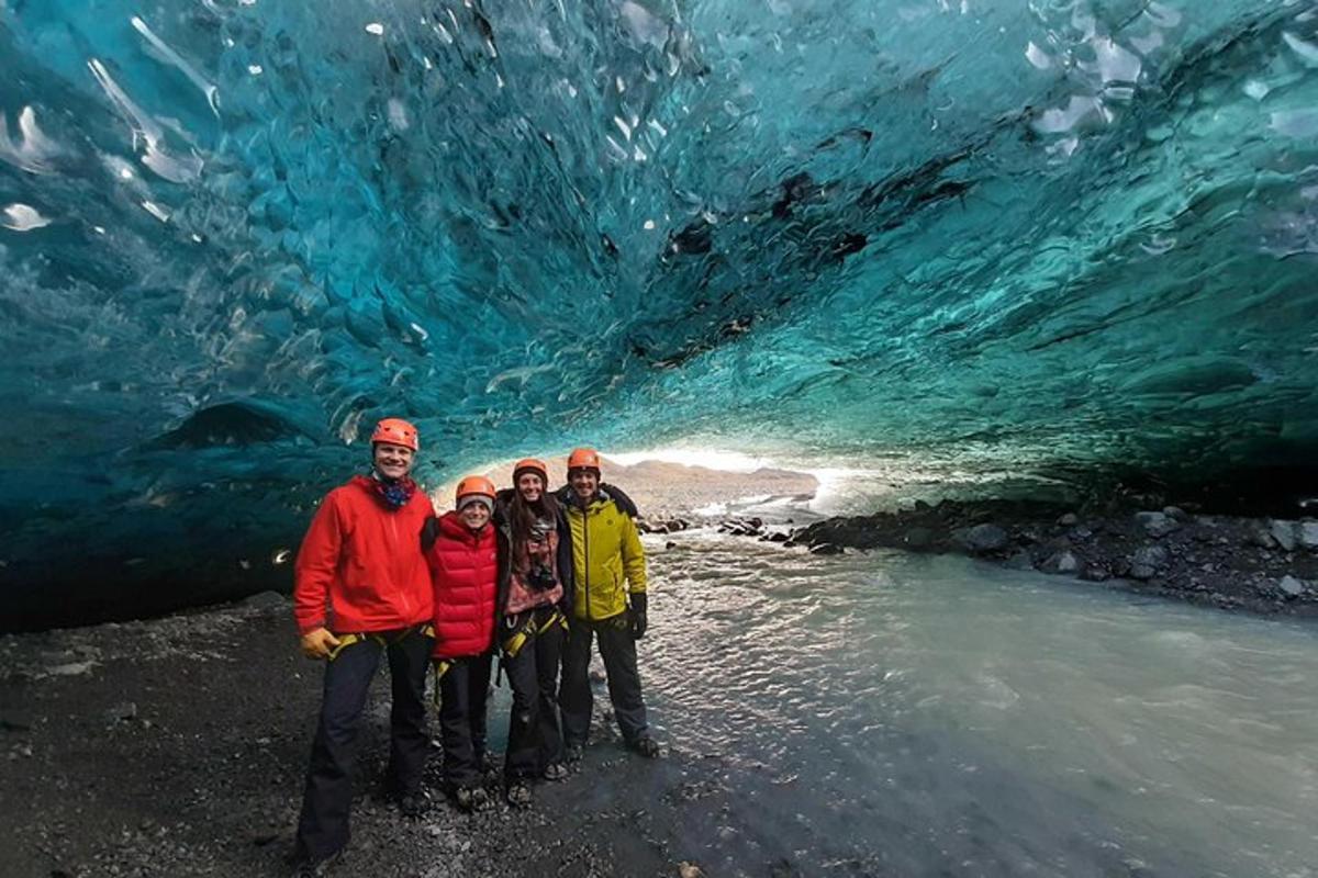 un gruppo di persone in piedi davanti a una grotta di ghiaccio