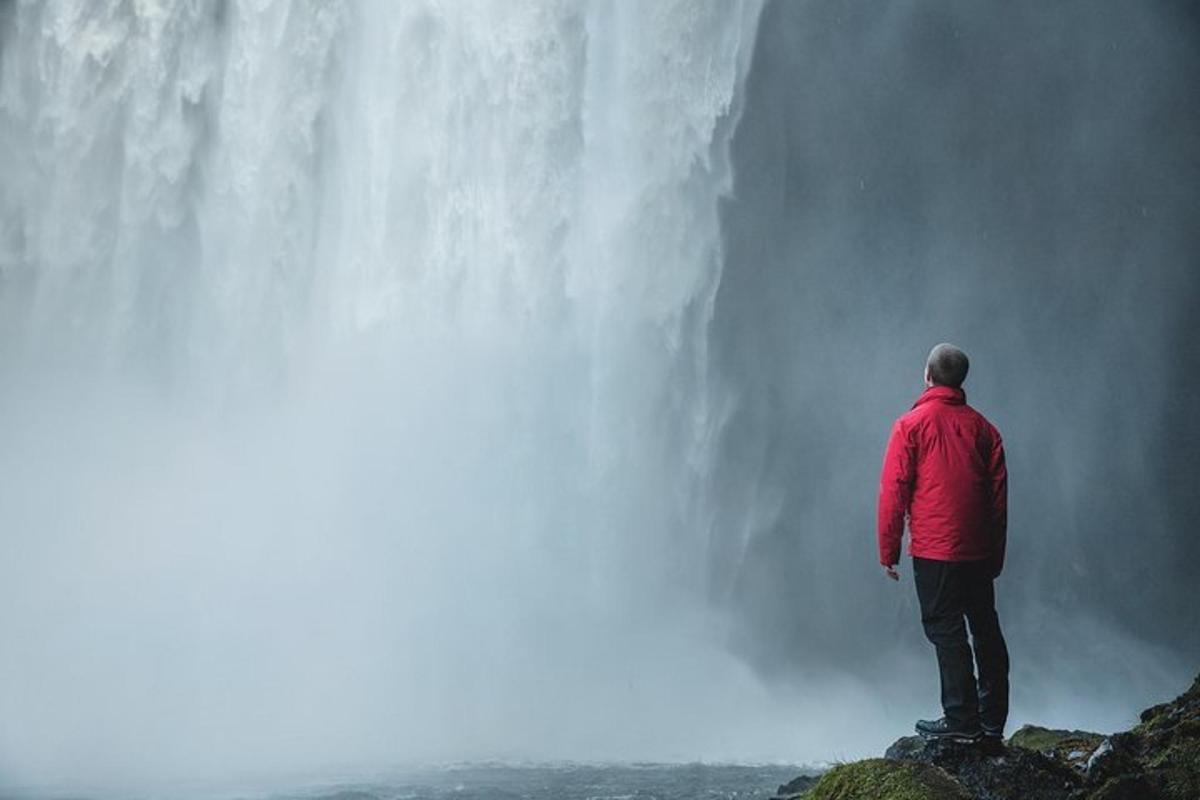 un uomo in piedi sul bordo di una cascata