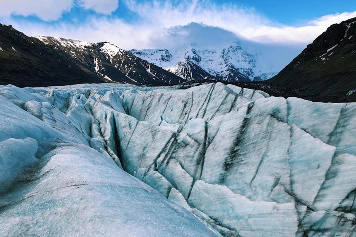 una glacera amb muntanyes nevades al fons