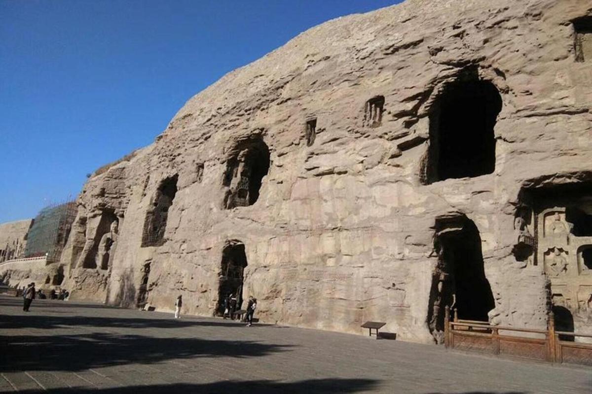 a rock wall with people standing in front of it