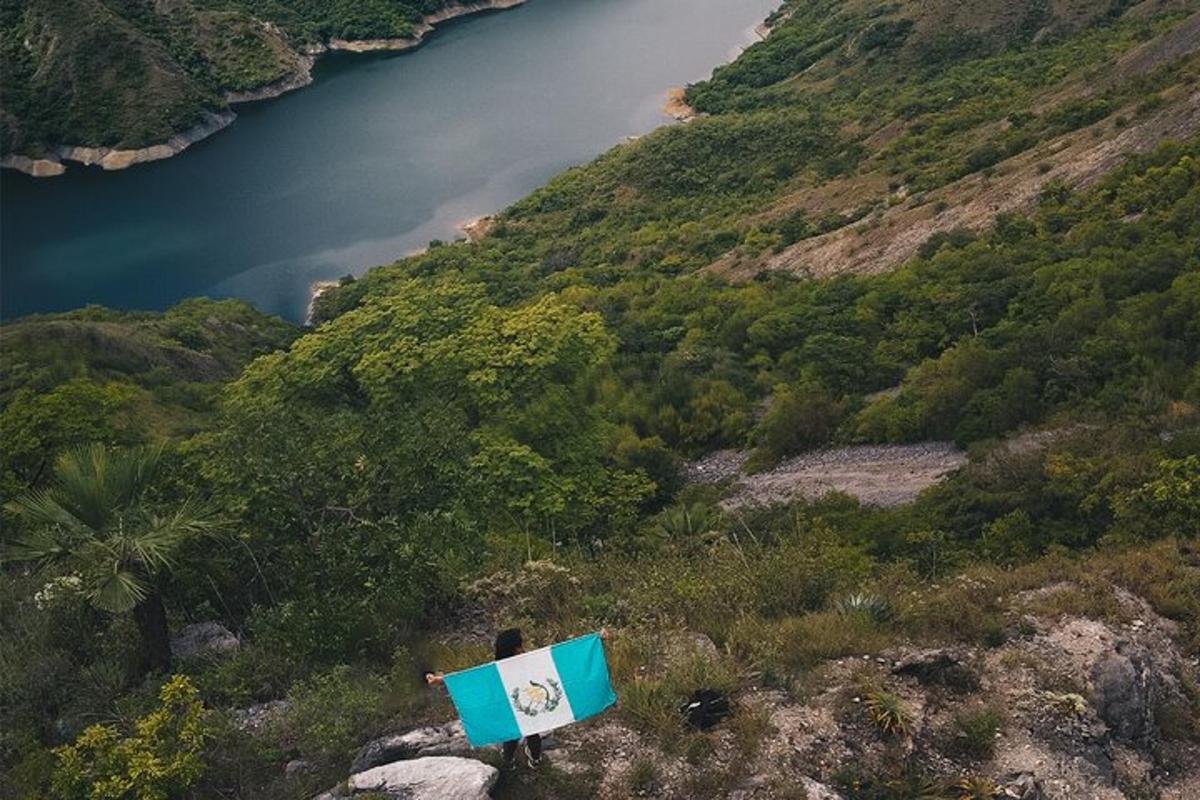 et blåt og hvidt skilt på en bakke med en sø
