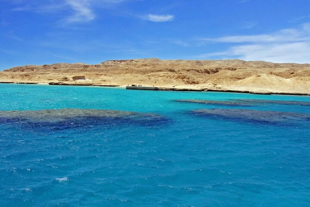 een groot blauw waterlichaam met bergen op de achtergrond