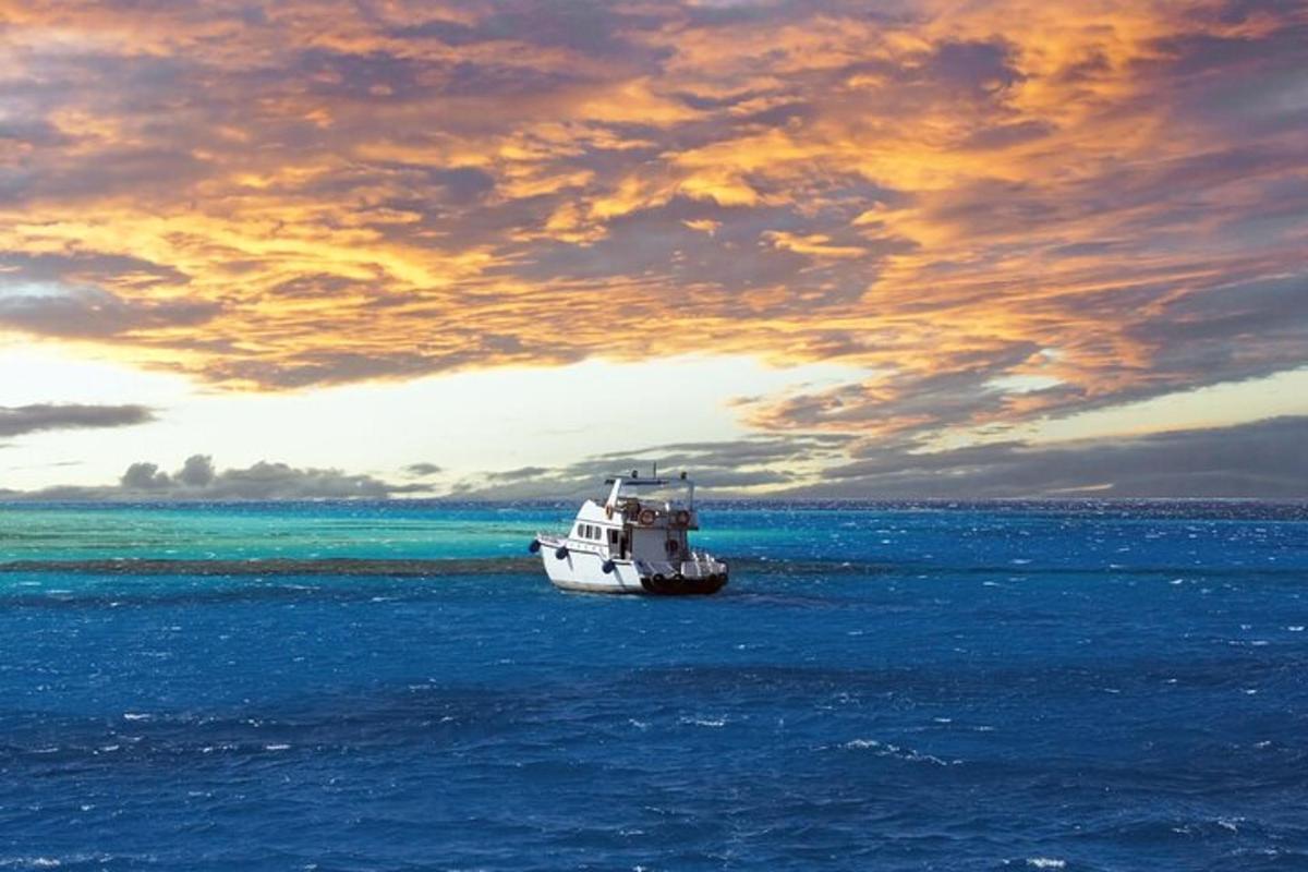 čoln v oceanu pod oblačnim nebom