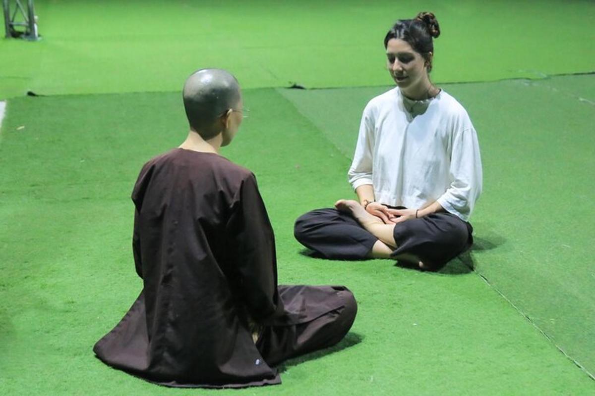 a man and a woman sitting on the floor in meditation