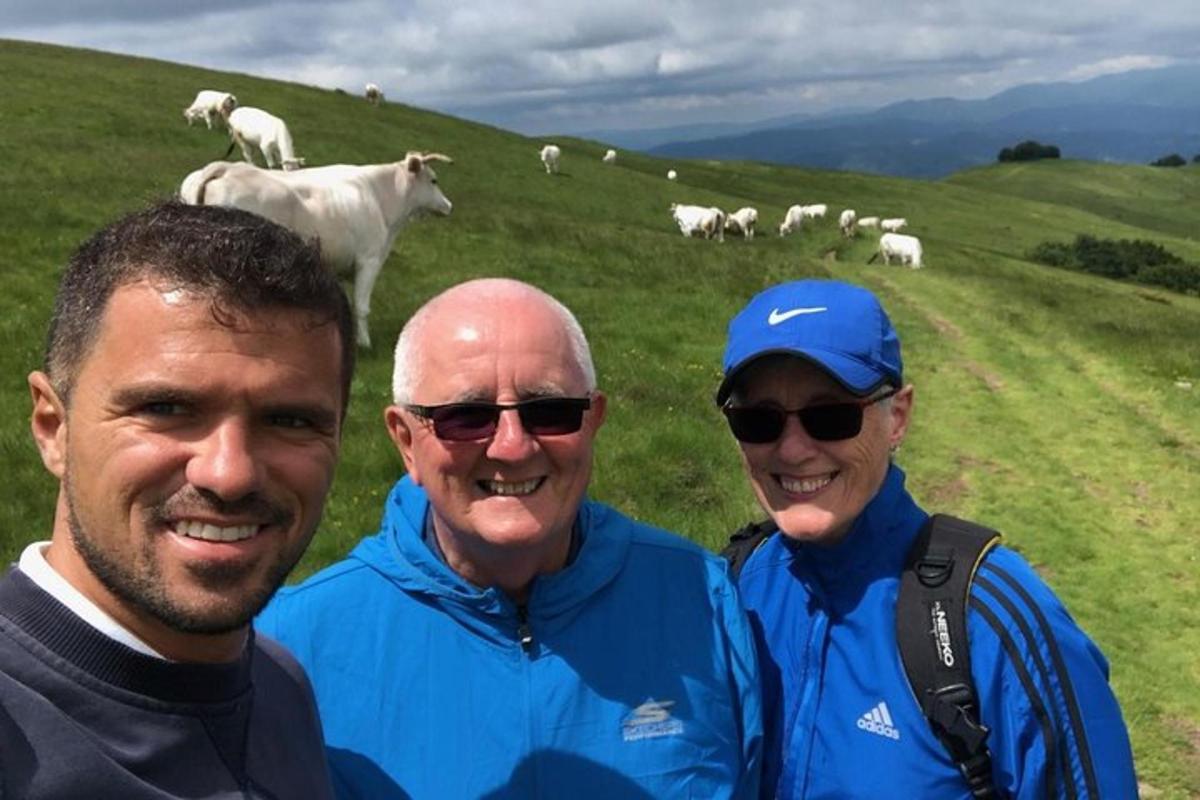 a group of three men standing in a field with sheep
