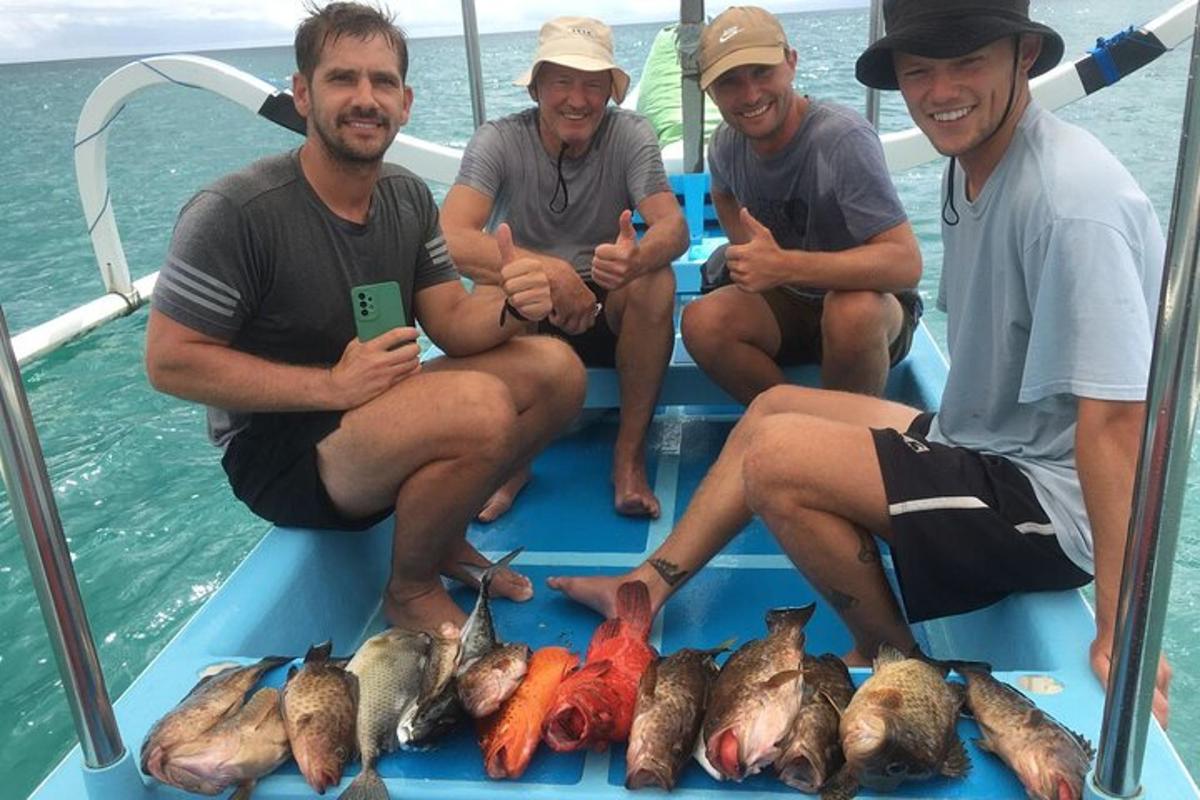 four men sitting on a boat with a bunch of fish