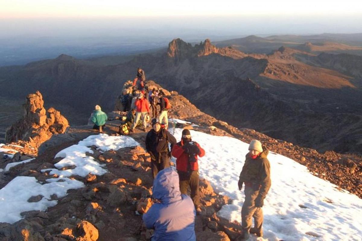 sekumpulan orang berdiri di puncak gunung
