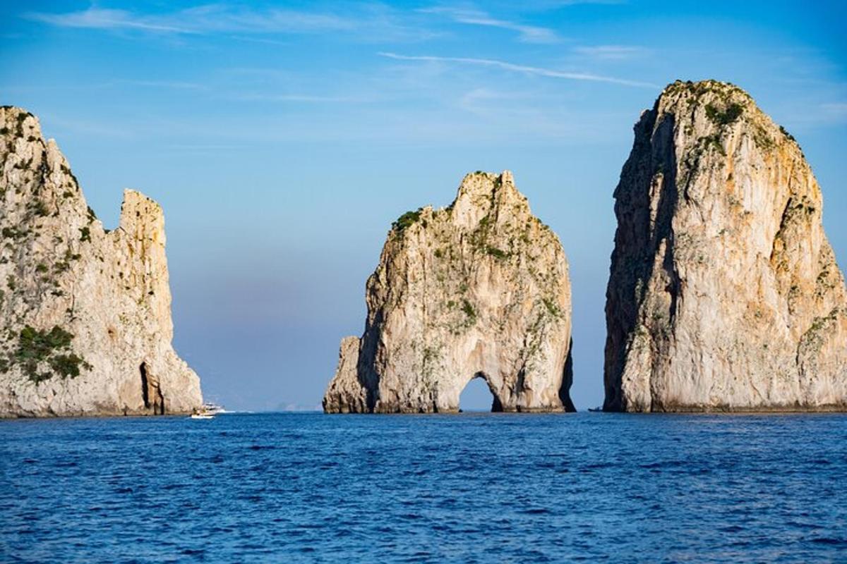 isang malaking rock formation sa tubig na may bangka