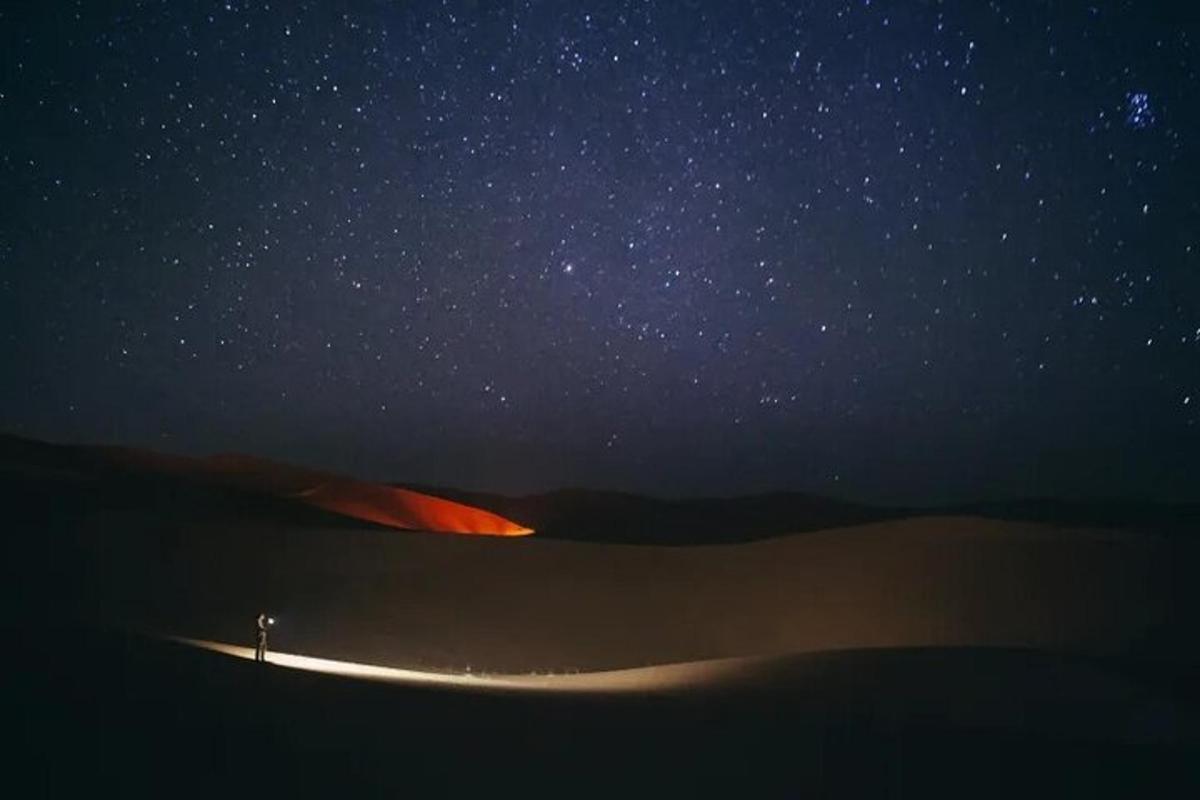 一个人站在星空下的沙漠中