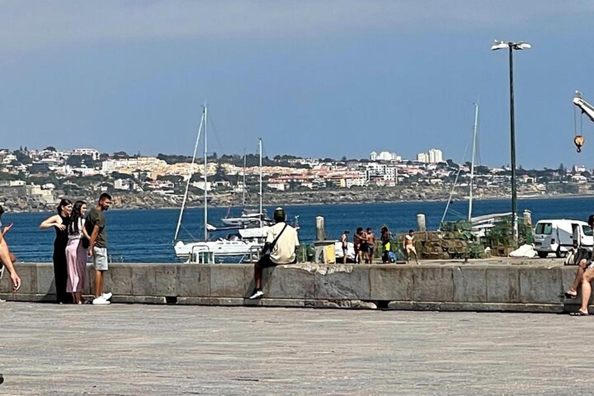 مجموعة من الأشخاص يقفون على رصيف بالقرب من الماء