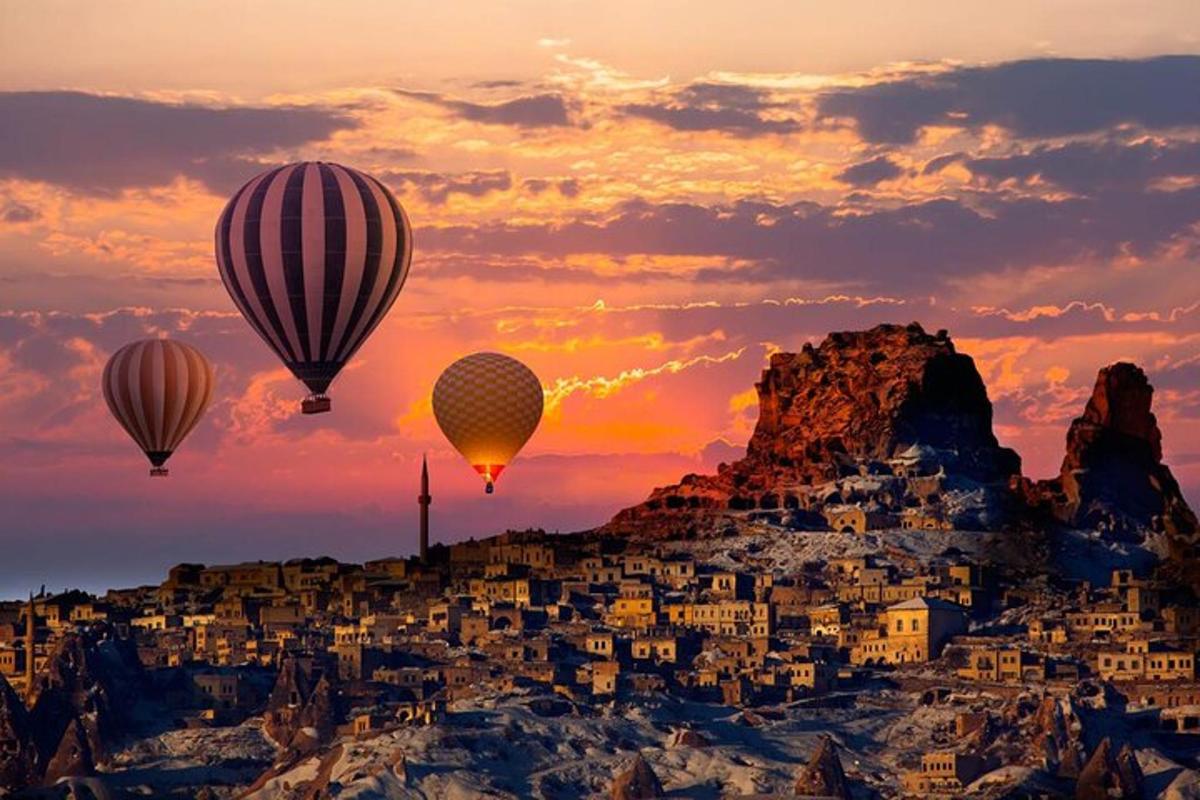 egy csoport hőlégballon repül egy város felett