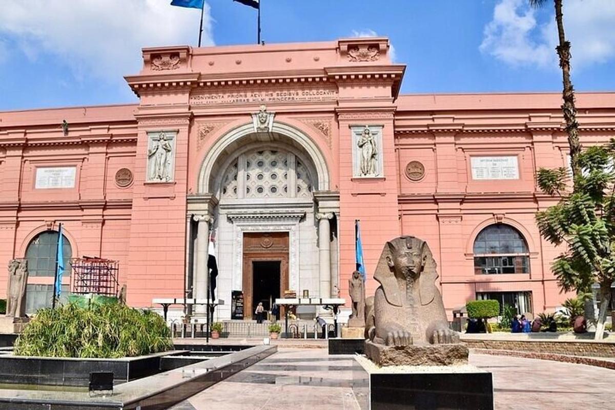 um prédio rosa com uma estátua na frente