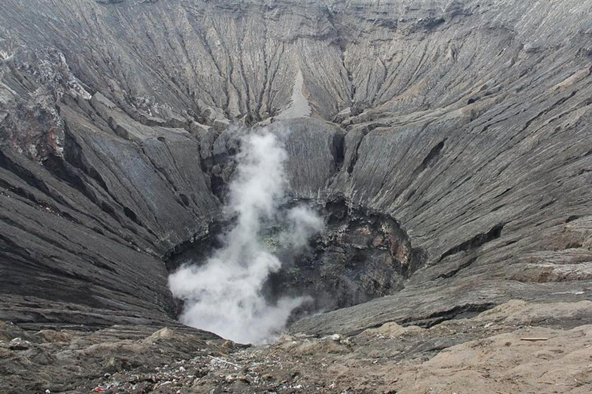 un geyser che emette fumo in una montagna rocciosa