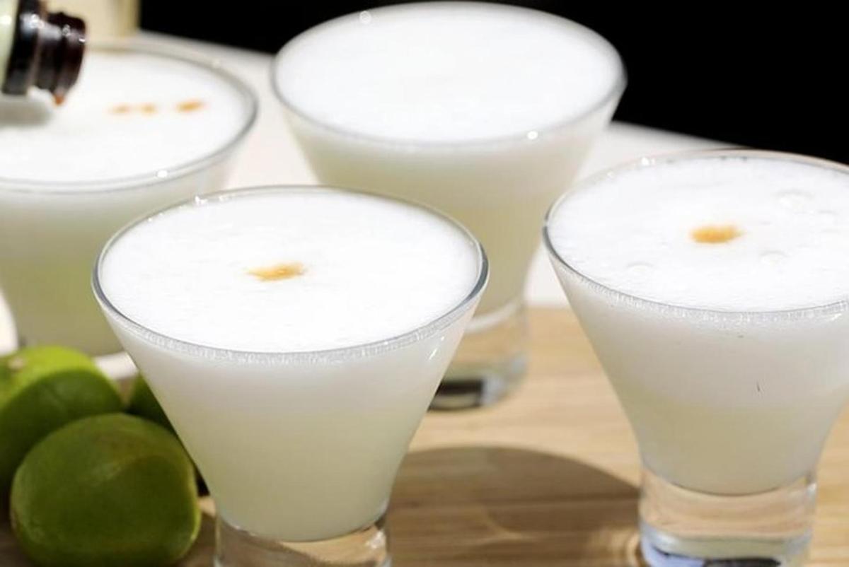 tre bicchieri di latte su un tavolo con lime