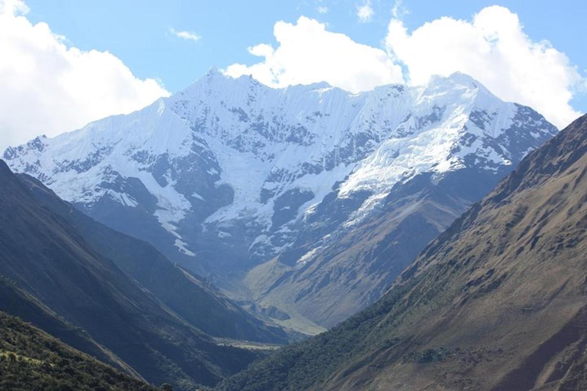 uma montanha coberta de neve com um vale na frente