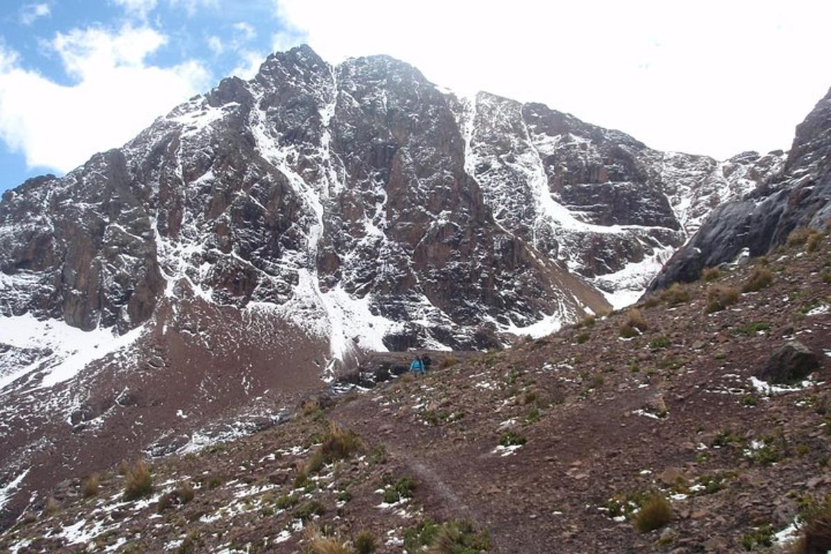 una montagna coperta di neve con due persone in piedi su una collina