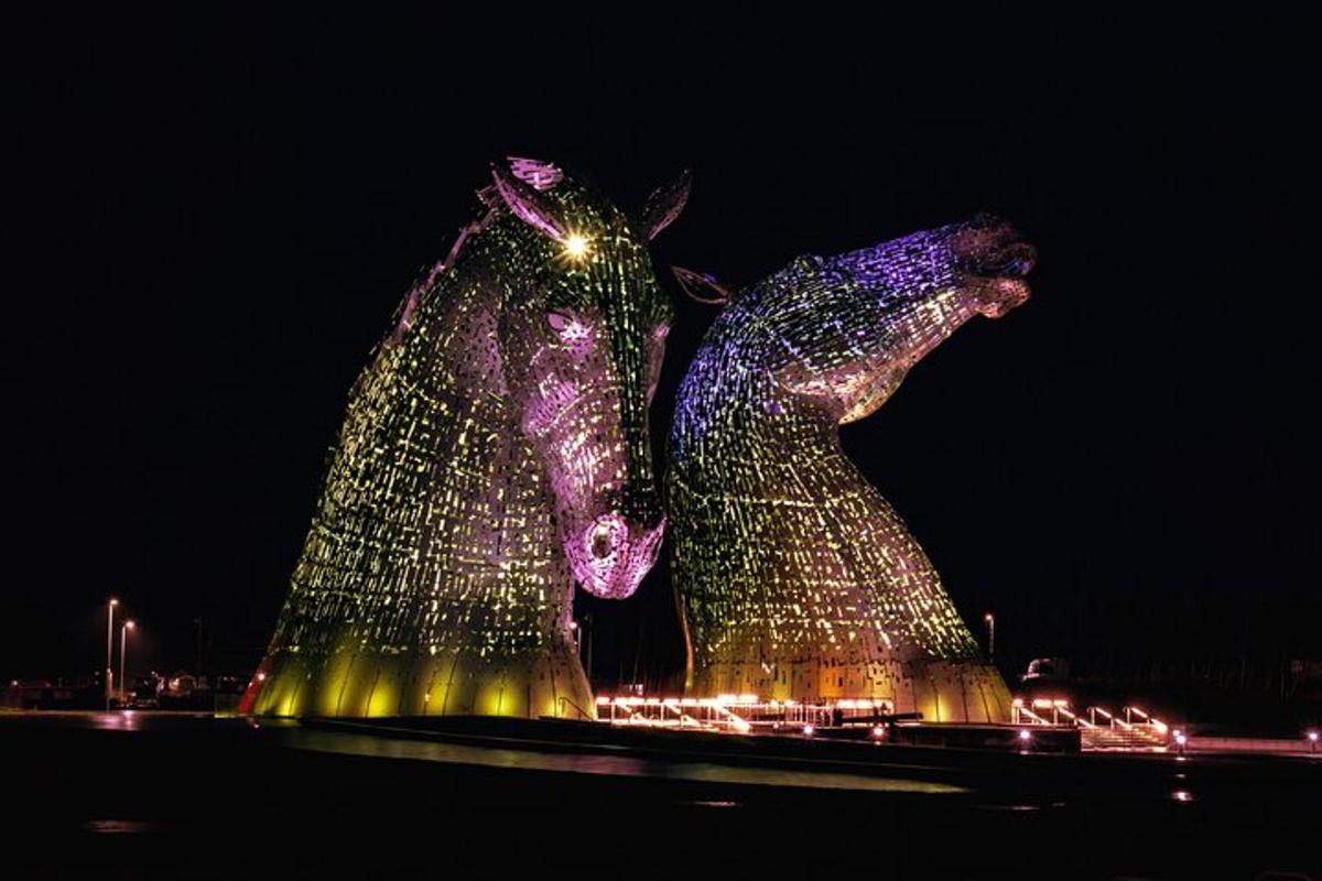 Dues escultures de cavalls il·luminades a la nit